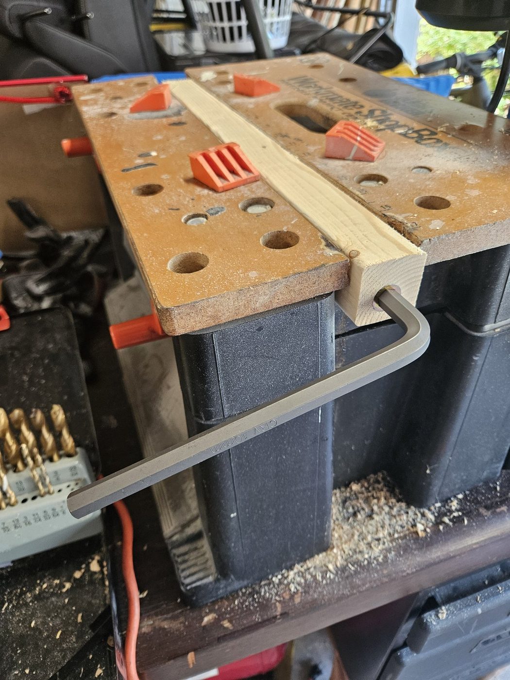 Driving a threaded insert into the end grain of a leg with a 10 mm hex wrench, leg clamped in the bench
