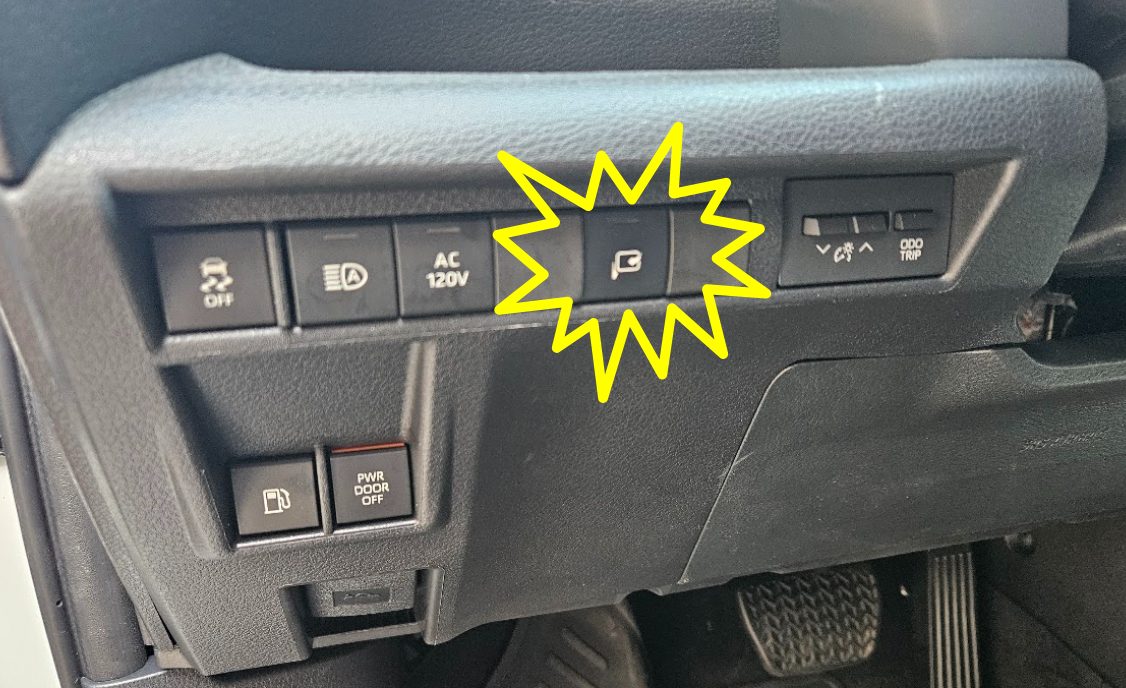 The retrofitted mirror-fold button in the Sienna's dash switch bank, beside the AC 120 V inverter switch